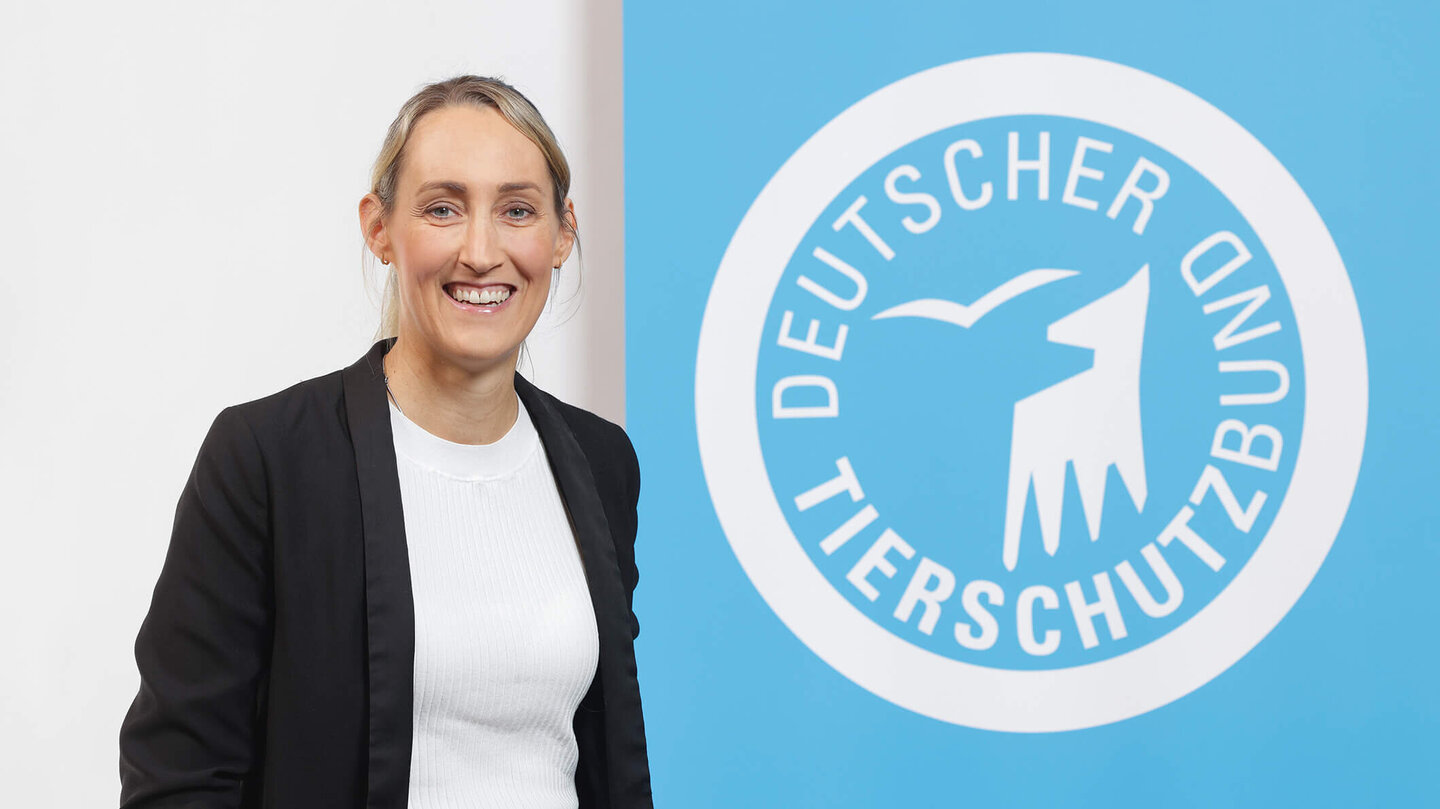 Portrait von Judith Schoenstein vor dem Logo des Deutschen Tierschutzbundes
