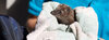Tierpflegerin sitzt im Tierschutzzentrum Weidefeld mit Igel im Handtuch